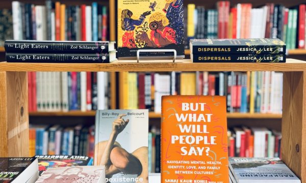 A table covered in a book display stands in front of a wall of bookshelves inside Wildfires Bookshop